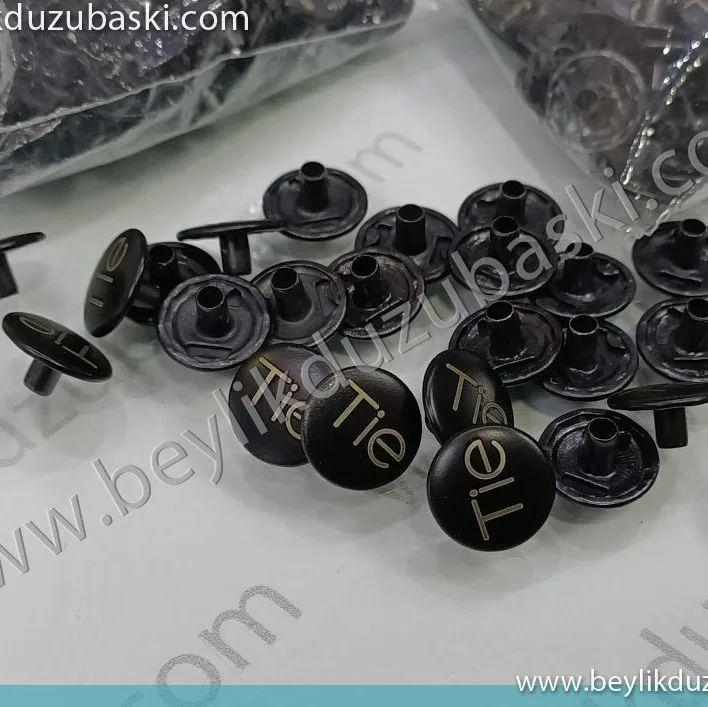 metal düğme üzerine baskı, lazer ile düğmeye baskı, gömlek düğmesi, pantolon düğmesi, gibi, metal düğmeler üzerine logo baskı yapılmasıdır